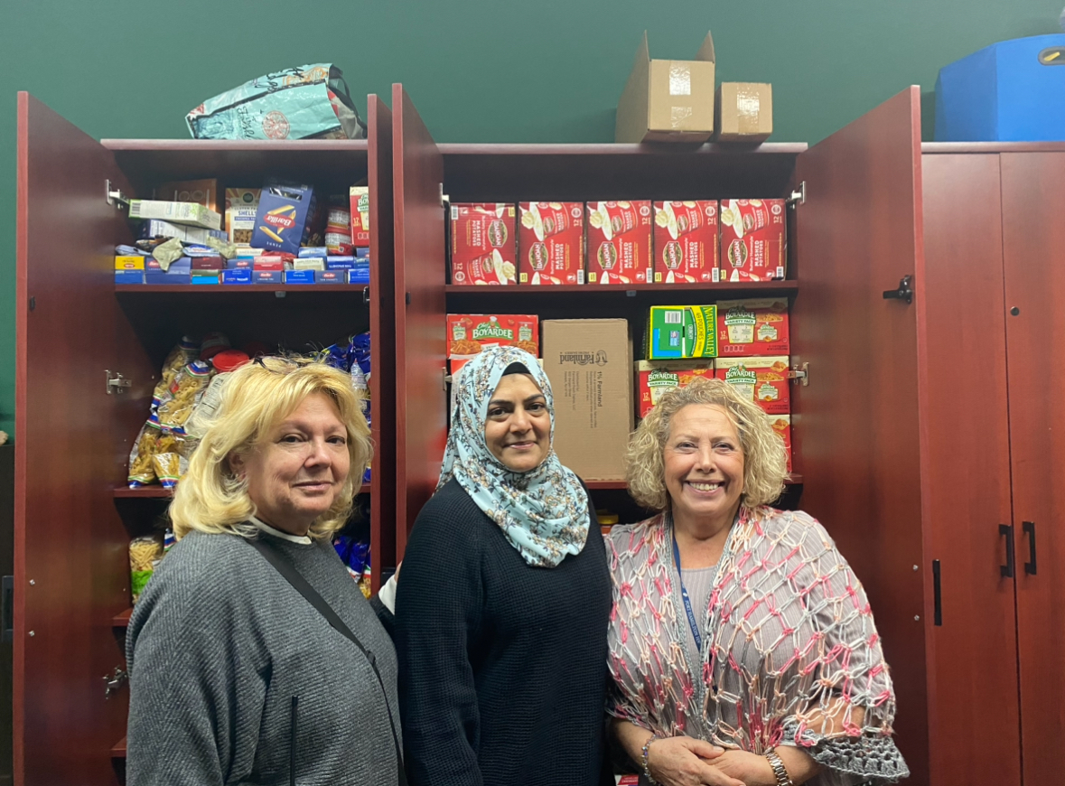 Mina Liakou, Fatima Ghazal and Isabel Cataldi stand in front of the food pantry.