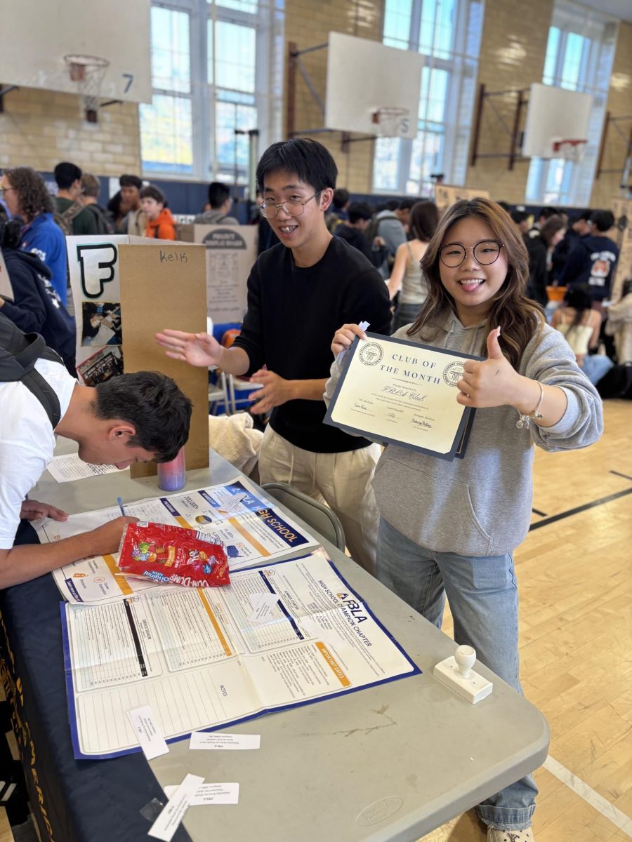 Fort student proudly displays a Club of the Month award.