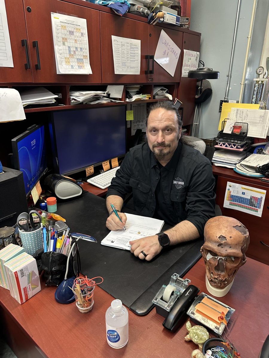 Mr. Christakos sits at his desk for the final time.