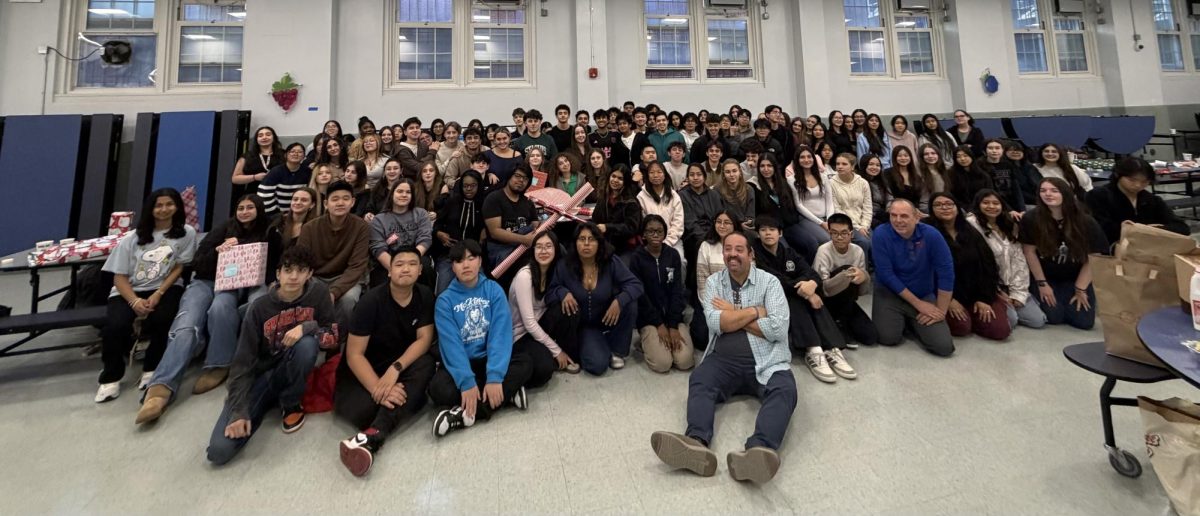 Students and staff pose for a photo at the end of the toy wrapping party.