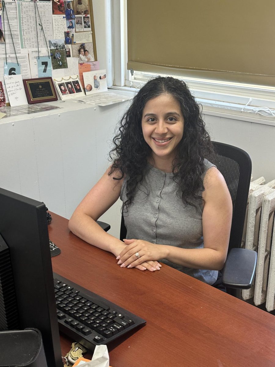 Dr. Tazghini poses for a photo at her desk in Room 209